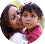 A mother and her young son cheek to cheek, in a round frame