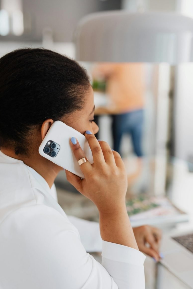 A woman speaking on a mobile phone at a desk