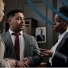 Three professionals in suits talking in a library