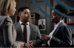 Three professionals in suits talking in a library